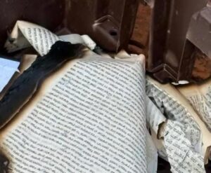"صفحات محترقة من كتاب تُشير إلى الخطر الذي يهدد التراث الثقافي والهوية المكتوبة"